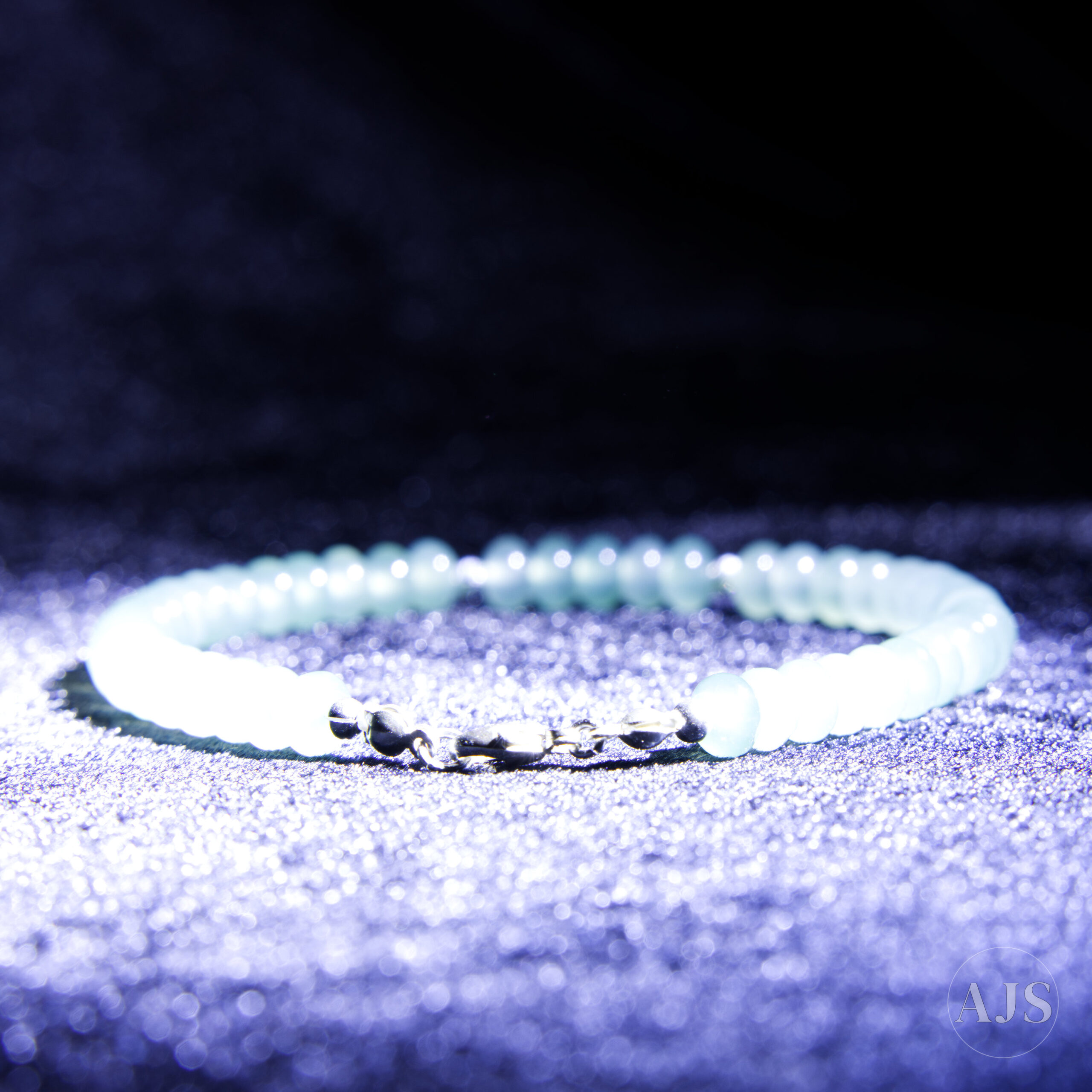 Backlit sea-green jadeite beads showing natural translucency and internal depth